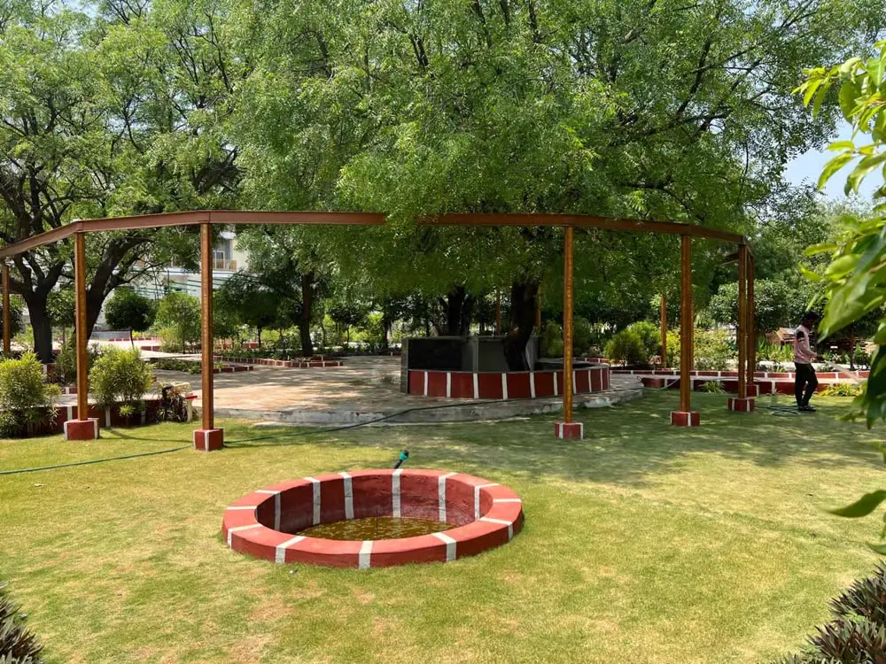 A curved swing pergola round a small brick pond on the lawn