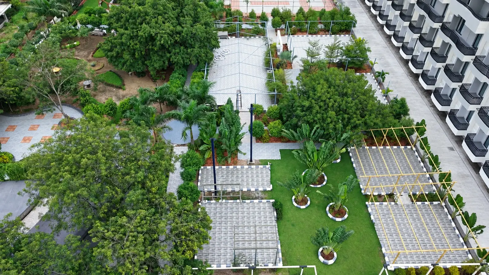 The gardens from above: lawns, palms, tiled pavilions and pergolas, with the hotel block alongside