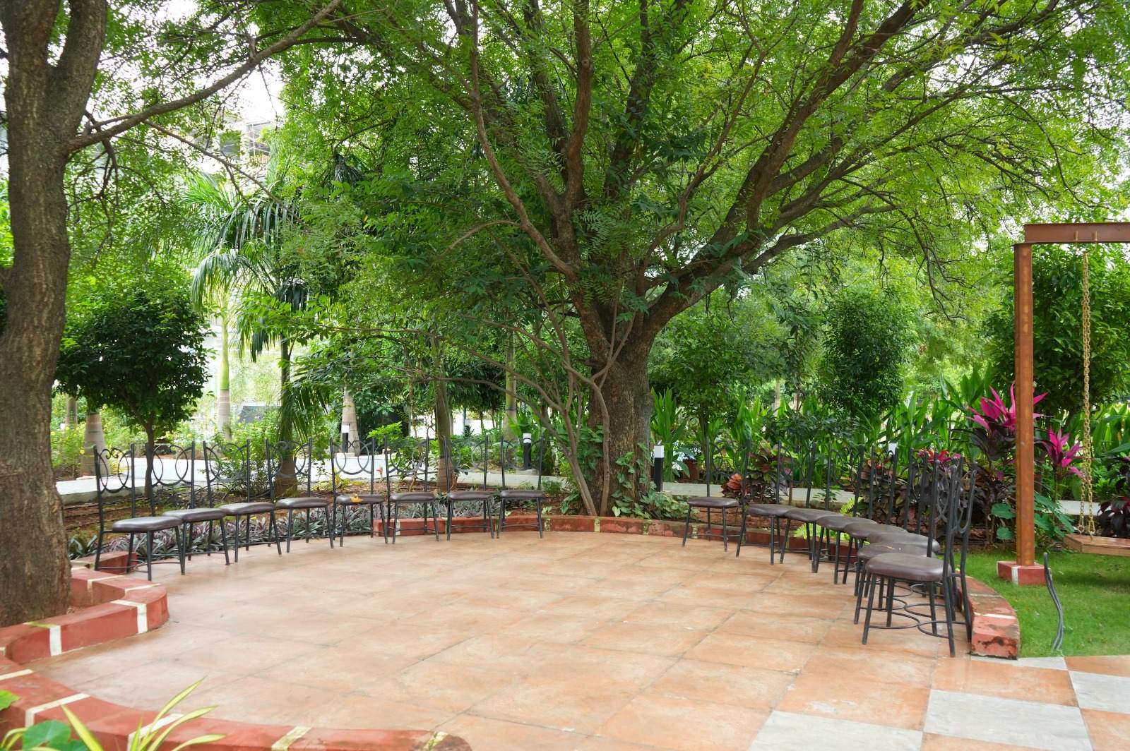 Benches round a tiled seating circle under a great shade tree