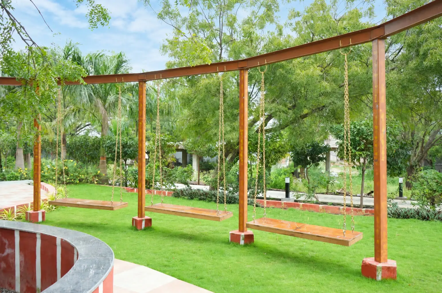 Wooden swings under a curved pergola on the lawn