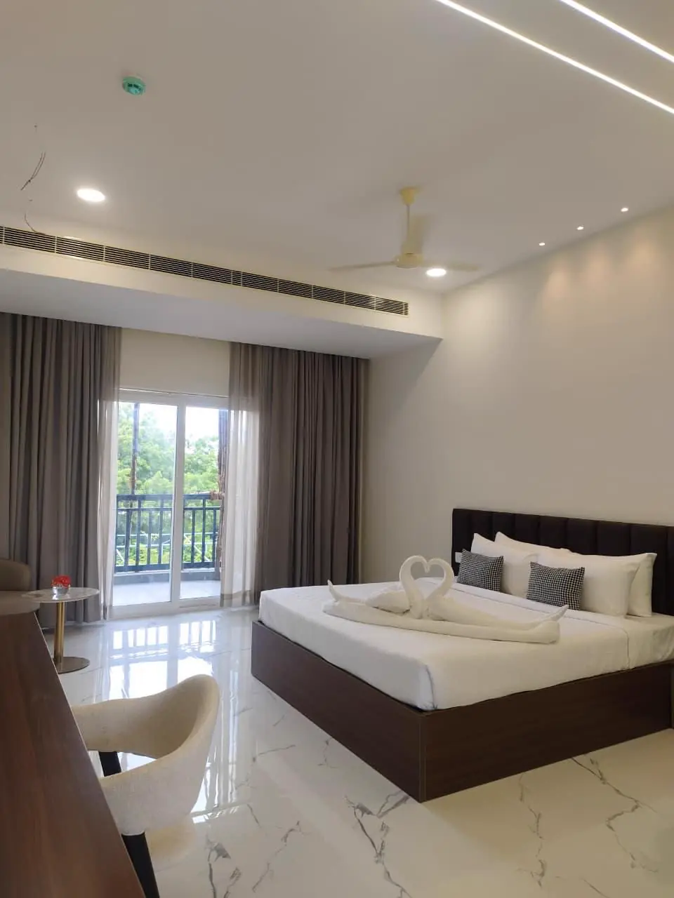 A guest room with a king bed and a balcony