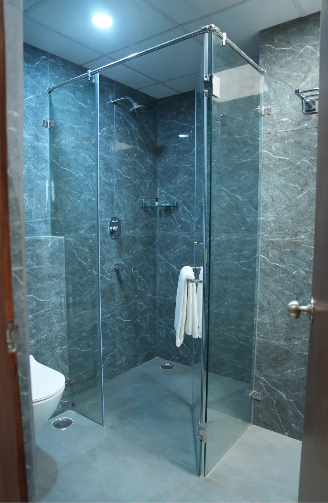 A marble bathroom with a glass-walled shower