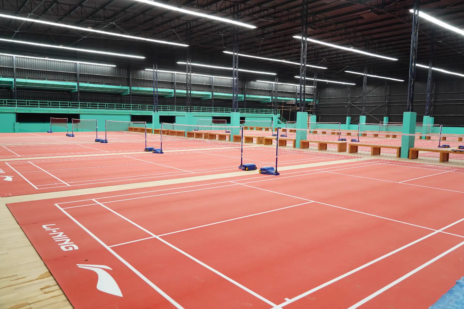 Rows of red badminton courts in the indoor hall