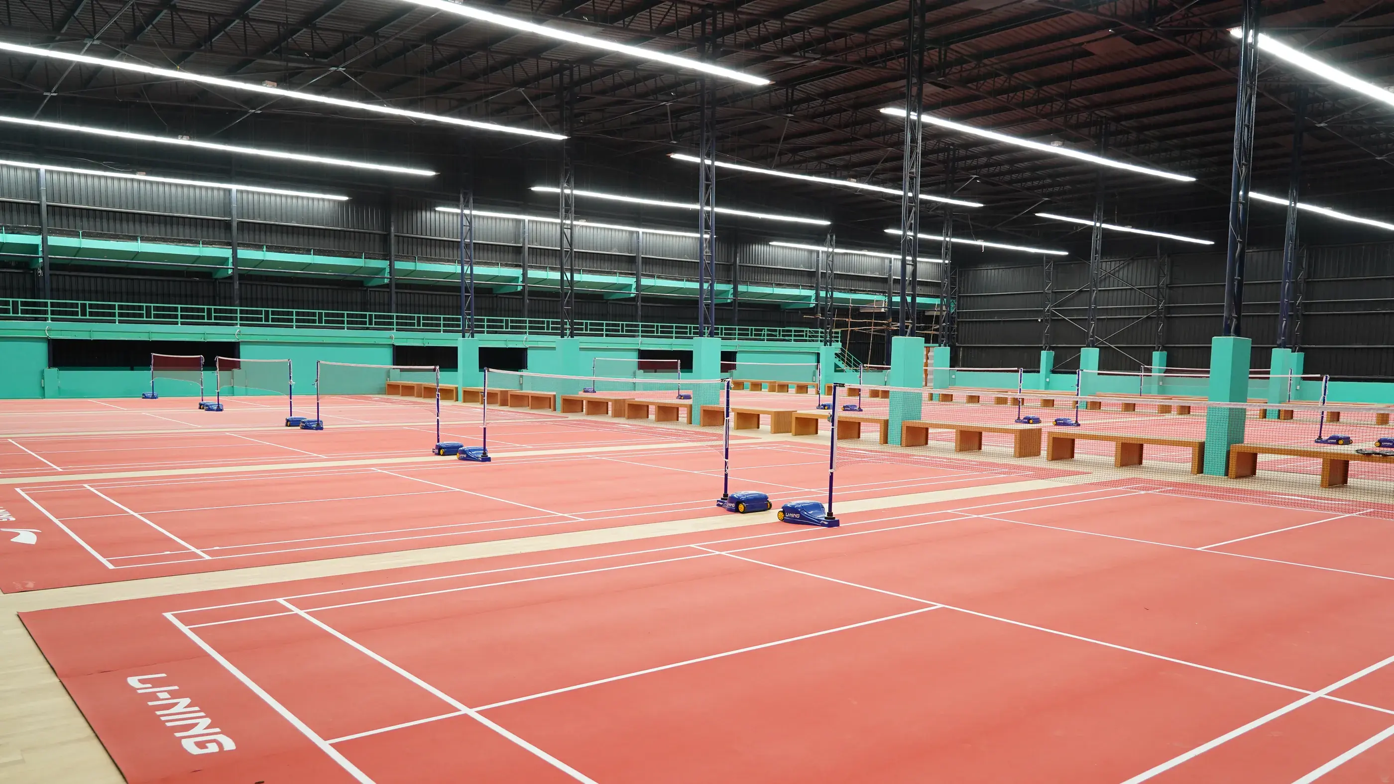 Rows of red indoor badminton courts under one roof