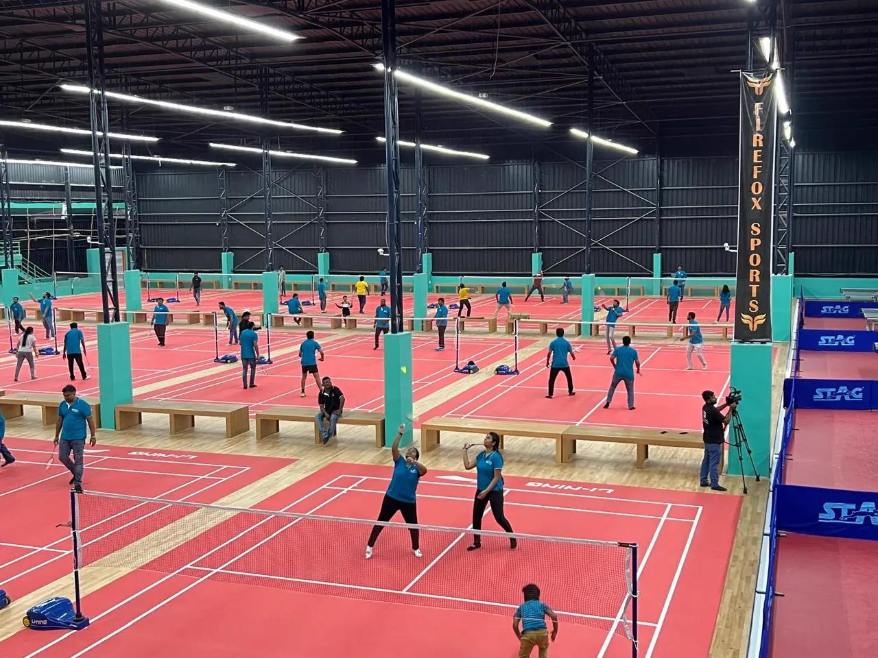 Players across the courts of the indoor badminton hall
