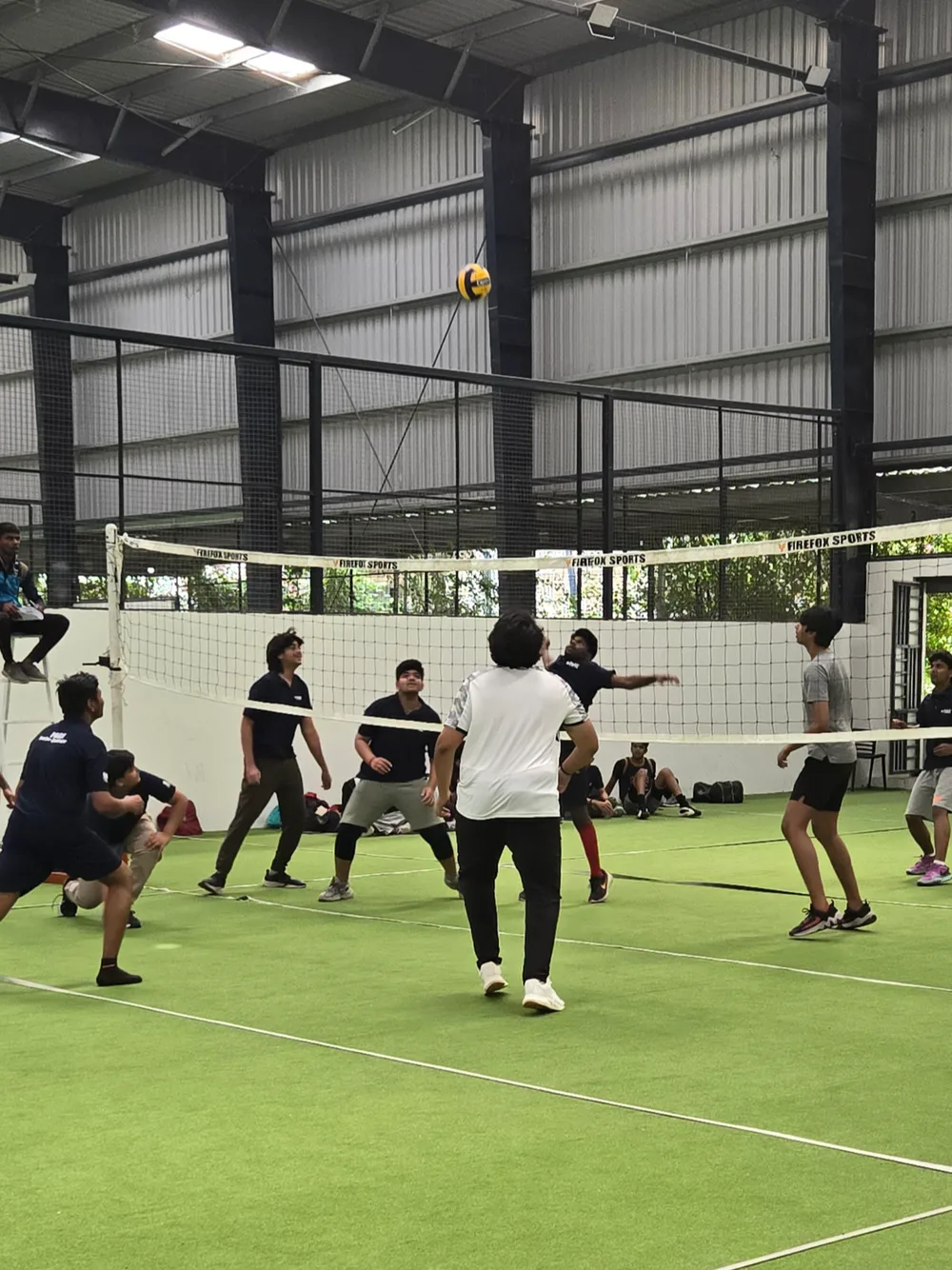 A volleyball match in play on the indoor turf