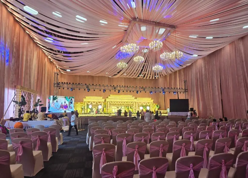 A blush-draped hall set with a wide mandap